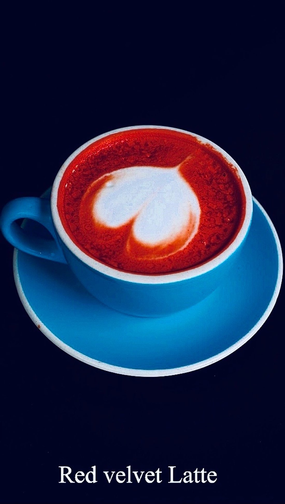 Red velvet latte with heart-shaped foam in a blue cup